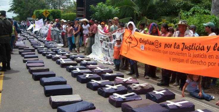 Members of the community San José de Apartadó gather behind model coffins, in a protest against violence they face.