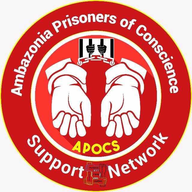 A red circle. In the middle are two hands in handcuffs. Around the edge are the words "Ambazonia Prisoners of Conscience Support Network"