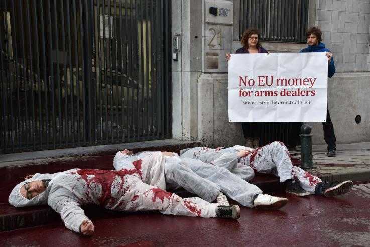 Activist lie on in a pool of fake blood