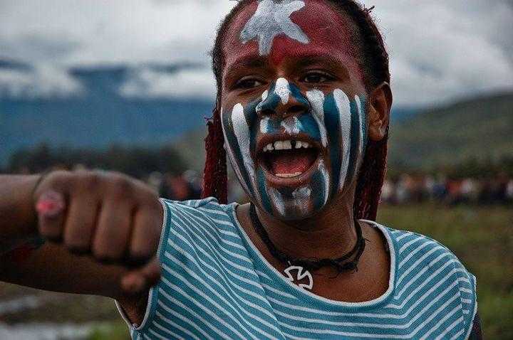 A young girl with the West Papuan flag at an independence rally