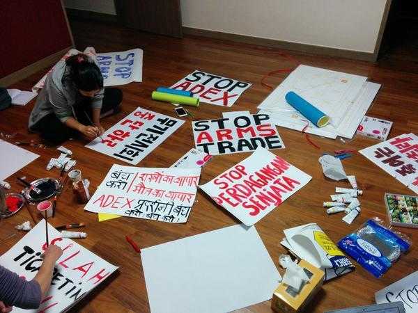 Two activists paint banners and placards in preparation for a protest