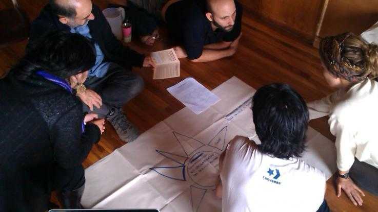 A group gather during a training session around a big piece of flipchart paper