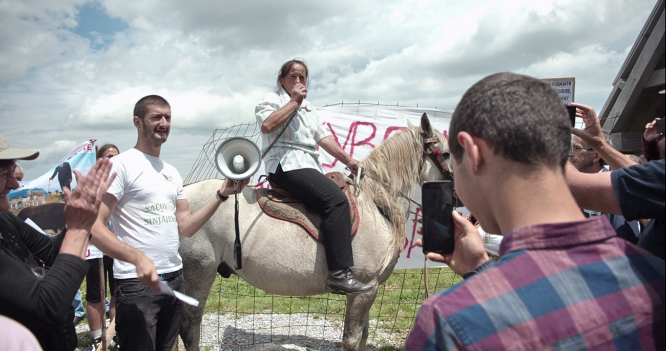 A protester sits on a horse, speaking into a megagphone