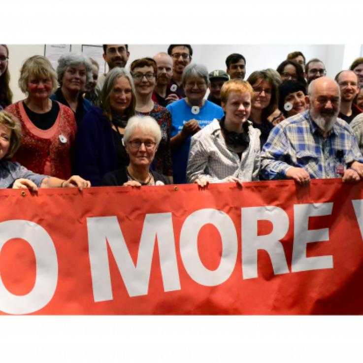 People holding a banner saying 'No more war'